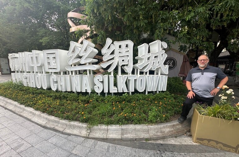 Litigator Wesley Johnson stands in front of the address for his client Hangzhou Chuanyue Silk Import & Export Co. during a 2025 trip to China, courtesy photo.