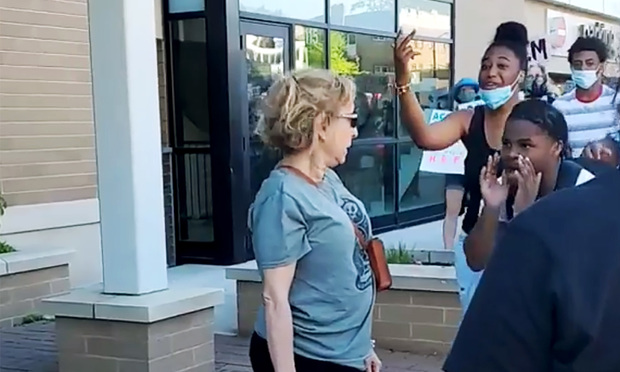Stephanie Rapkin is seen in this screen shot from cell phone video, on June 7 outside Metro Market on North Oakland Avenue in Shorewood, Wisconsin, being screamed at by protesters moments before she spits on a the teenager on the right of the image during a march to protest the killing of 46 year old George Floyd at the hands of Minneapolis Police. Rapkin had parked her car on the street to block the march and then got out of her car to confront the demonstrators.