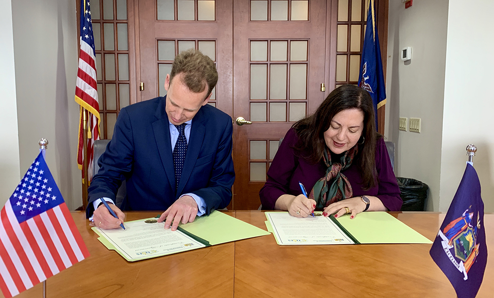 Frank Elderson, chairman of the NGFS, and Linda A. Lacewell, superintendent of the DFS, signing the agreements. Courtesy photo of DFS