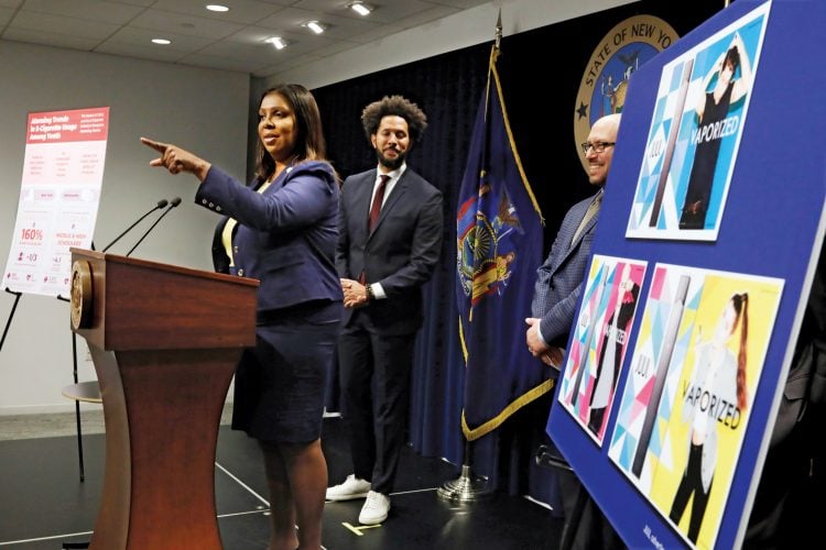 New York State Attorney General Letitia James speaks during a news conference at her office in New York, Tuesday, Nov. 19, 2019. New York has joined the ranks of states suing the nation's biggest e-cigarette maker, San Francisco based JUUL Labs. At background left and right are Andre Richardson, campaign manager of Flavors Hook Kids, and East Hampton High School Principal Adam Fine. (AP Photo/Richard Drew)