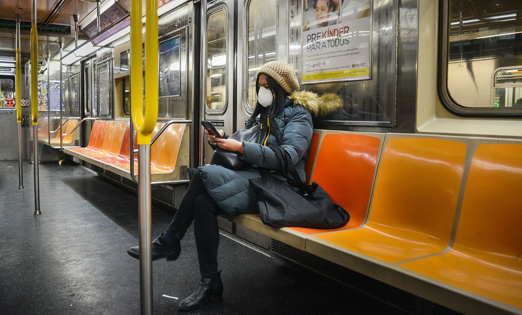 A commuter wears a face mask as she sits alone on the subway during the coronavirus pandemic in New York, Tuesday, March 17, 2020. Photo: Ryland West/ALM