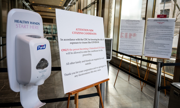 Purell container and sign announcing courts partial closure due to coronavirus at Manhattan state courthouse.