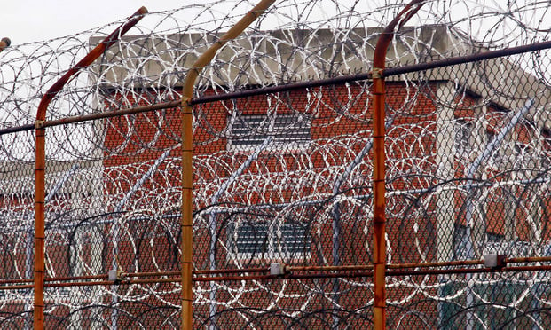 In this March 16, 2011, file photo, a security fence surrounds inmate housing on the Rikers Island correctional facility in New York. (AP Photo/Bebeto Matthews, File)