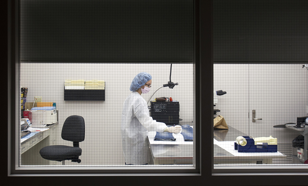 A forensic scientist at the New York State Police Forensic Investigation Center in Albany screens a pair of jeans for biological evidence. The proposed law, which would allow juveniles to apply to Family Court for the expungement of their DNA records, has still not been passed, according to legislative records. Photo: Mike Groll/AP