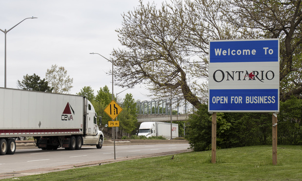 "Welcome to Ontario, Open for Business" sign seen as transport truck enters the U.S.-Canada border