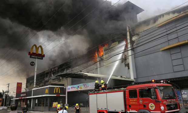 Firefighters battle a fire that rages at a shopping mall and call center in December 2017 in Davao city, southern Philippines.