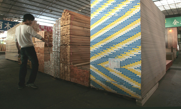 A man walks past stacks of drywall at a wholesale market in Shanghai, China, on Monday, Oct. 26, 2009. Photographer: Kevin Lee/Bloomberg