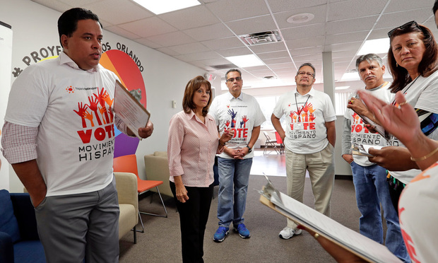 Betsy Franceschini, second from left, senior state director of the Florida Southeast Hispanic Federation, briefs a group of canvassers before they go out to register Hispanic voters in Orlando. (AP Photo/John Raoux)