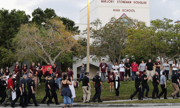 Police walk outside Marjory Stoneman Douglas High School in Parkland on Feb. 28 as students returned to class for the first time since a former student opened fire there with an assault weapon. (AP Photo/Terry Renna)