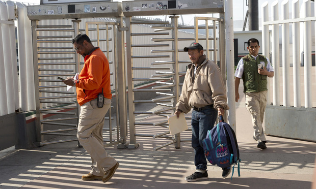 Carlos Catarldo Gomez, of Honduras, center, is escorted by Mexican officials after leaving the United States, the first person returned to Mexico to wait for his asylum trial date, in Tijuana, Mexico. (AP Photo/Gregory Bull)