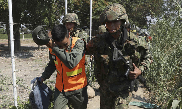 A Colombian soldier escorts a Venezuelan National Guard who deserted his post near the Simon Bolivar International Bridge, in La Parada, Colombia, Monday, Feb. 25, 2019. Photo: Fernando Vergara/AP