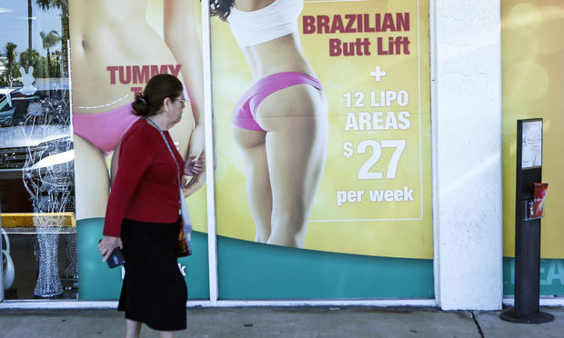 A window display advertises low-cost cosmetic procedures outside a surgery clinic in Miami. (AP Photo/Ellis Rua)
