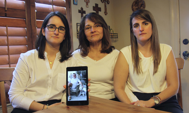 Dennysse Vadell sits between her daughters Veronica, right, and Cristina holding a digital photograph of father and husband Tomeu, who is currently jailed in Venezuela, in Katy, Texas. Tomeu Vadell is one of six executives from Houston-based Citgo who has spent 15 months jailed in Venezuela on what their families say are trumped-up corruption charges. (AP Photo/John L Mone, File, File)