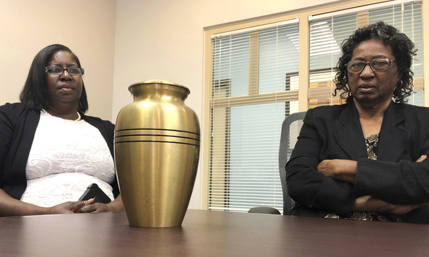 Corene Nero, right, and her daughter Gloria Rolle speak at their attorneys office next to an urn with cremated remains, in Boca Raton, Florida, April 16, 2019. Robert Nero Sr. passed away in 2013 and was cremated by Taylor Smith funeral home. In March, West Palm Beach police found a box with Robert Nero's name on it filled with ashes. Now the family is demanding answers from the funeral home and want to return the remains they have to the right family. (AP Photo/Josh Repogle)