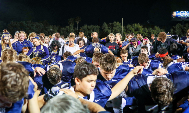 Cambridge Christian School students praying at high school football game. Photo by Beth Dare Photography/First Liberty Institute