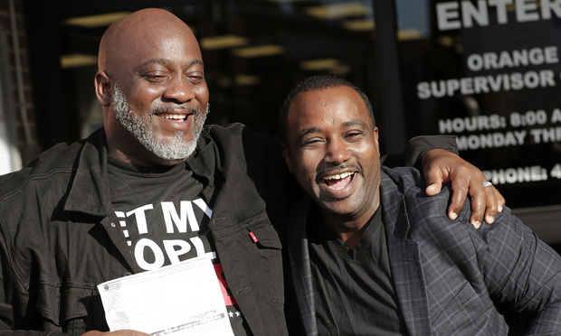 Desmond Meade, president of the Florida Rights Restoration Coalition, left, and David Ayala, husband of State Attorney Aramis Ayala, celebrate after registering to vote at the Supervisor of Elections in Orlando. (AP Photo/John Raoux, File)