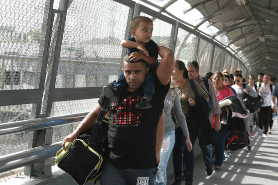 Cuban migrants are escorted by Mexican immigration officials in Ciudad Juarez, Mexico, as they cross the Paso del Norte International bridge to be processed as asylum seekers on the U.S. side of the border. Burgeoning numbers of Cubans are trying to get into the U.S. by way of the Mexican border, creating a big backlog of people waiting on the Mexican side for months for their chance to apply for asylum. April 29, 2019. (AP Photo/Christian Torres)
