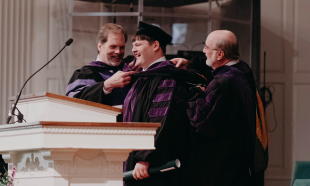2018 Baylor Law graduate Ty Drury receives his J.D. from professor Jim Wren (left) and professor Jerry Powell (right). (Photo: Baylor University School of Law)