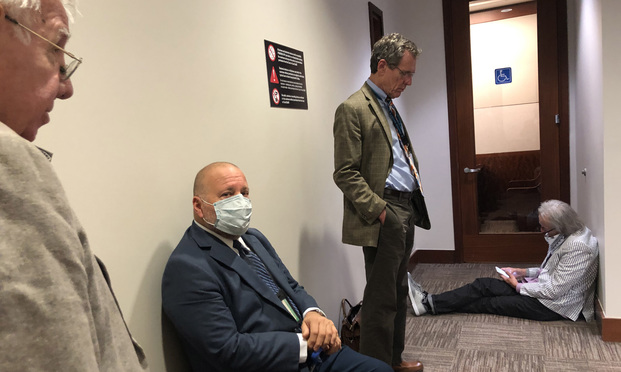 Lawyers wait in a hallway of the Harris County Civil Courthouse in Houston