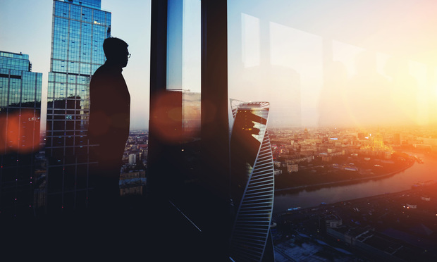 Silhouette of young intelligent man managing director resting after late business meeting while standing near big office window background with copy space for your text message or promotional content, city, city skyline, skyline