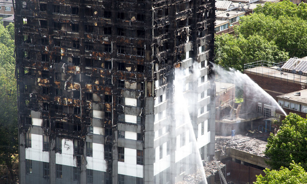 A hose continues to douse the fire at Grenfell Tower on June 15 2017, in London