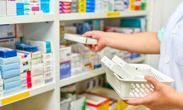 Pharmacist filling prescription in pharmacy drugstore. Credit: i viewfinder/Shutterstock.com