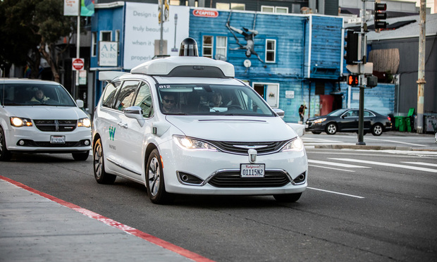 A Waymo, customized Chrysler Pacifica Hybrid, used for Google's autonomous vehicle program drives down 8th Street in San Francisco