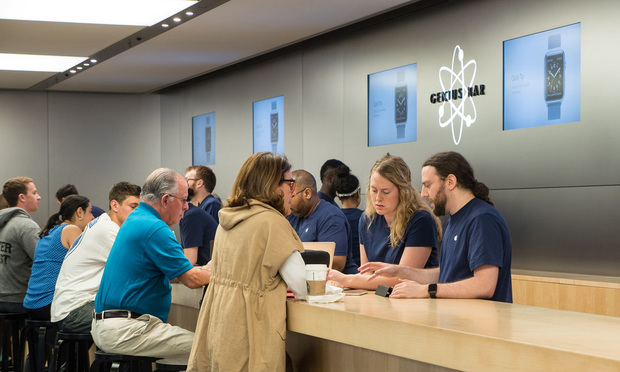 People at Genius Bar inside Apple store.