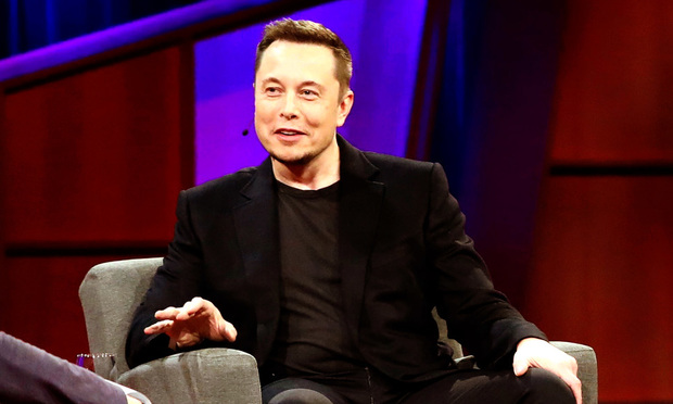 Elon Musk sitting in a chair