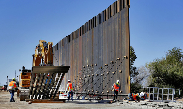 Government contractors erect a section of Pentagon-funded border wall along the Colorado River, Tuesday, Sept. 10, 2019 in Yuma, Ariz. The 30-foot high wall replaces a five-mile section of Normandy barrier and post-n-beam fencing along the the International border that separates Mexico and the United States. Construction began as federal officials revealed a list of Defense Department projects to be cut to pay for President Donald Trump's wall. (AP Photo/Matt York)