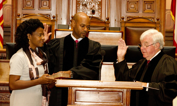 Justice Harold Melton takes the oath on a Bible held by his wife, Kimberly, administere by outgoing Chief Justice P. Harris Hines. (Photo: John Disney/ALM)