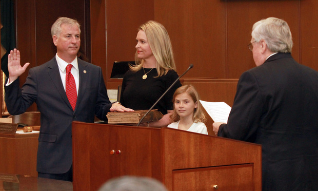 Kenneth Hodges (left) is administered the judicial oath by retired Court of Appeals Judge Edward Johnson as his wife, Melissa, and daughter, Margaret, stand by. (Photo: John Disney/ALM)