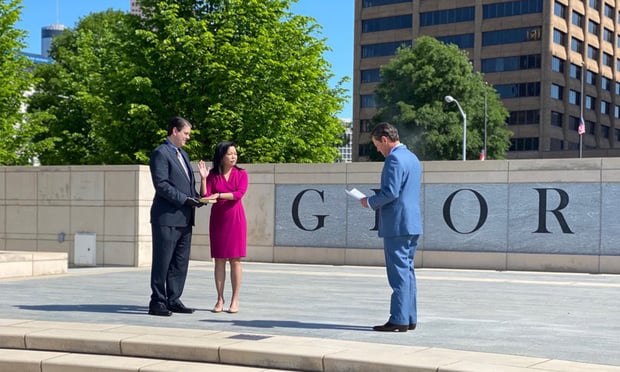 Georgia Gov. Brian Kemp (right) administers the oath of office to Judge Carla Wong McMillian, wgi joined the Supreme Court of Georgia on Friday. Her husband held the Bible. (Courtesy photo)