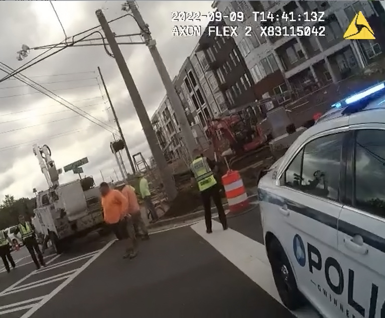 Screenshot of police body cam footage showing a utility truck improperly blocking a crosswalk.